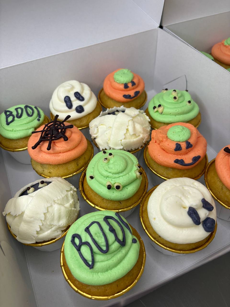 Halloween themed corporate cupcakes with ghosts pumpkins and BOO decor
