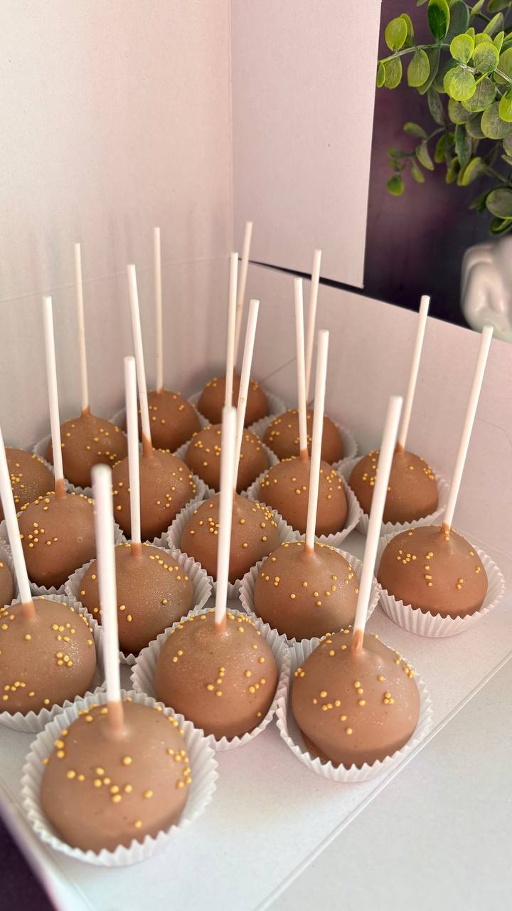 Milk chocolate cake pops with gold sprinkles in a gift box