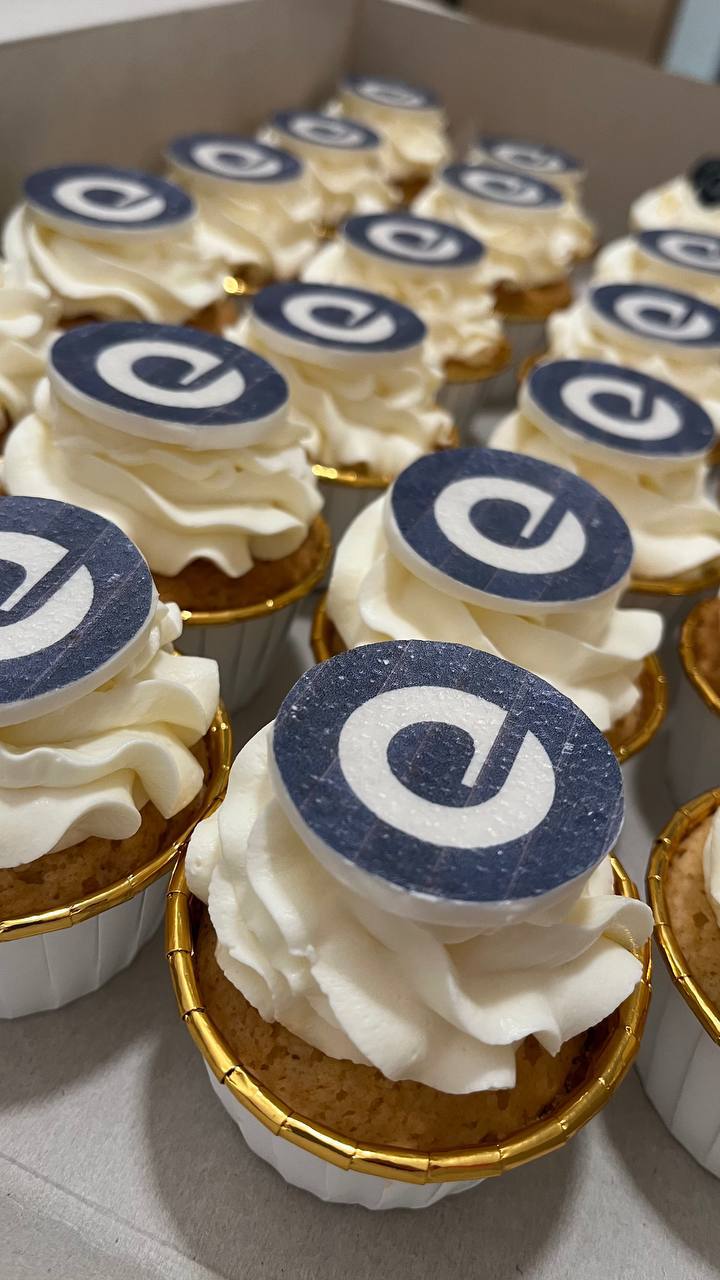 Corporate cupcakes with Expedia Group edible logo toppers in gold liners