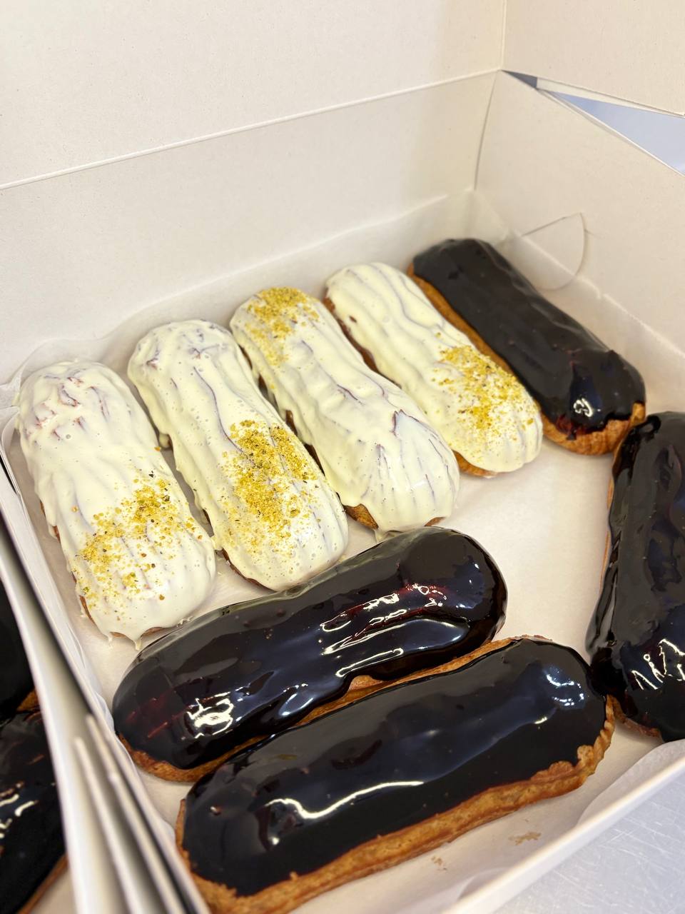 Eclairs box with white pistachio and dark chocolate glaze