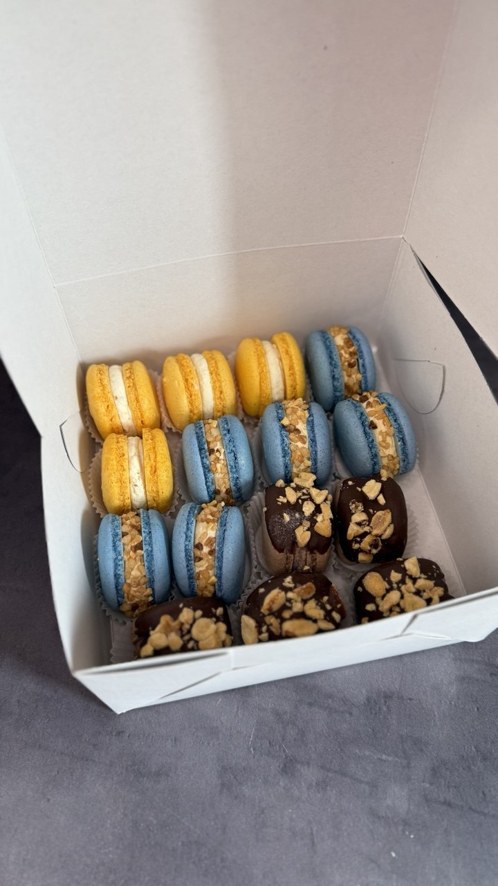 Box of yellow and blue macarons with nuts and chocolate