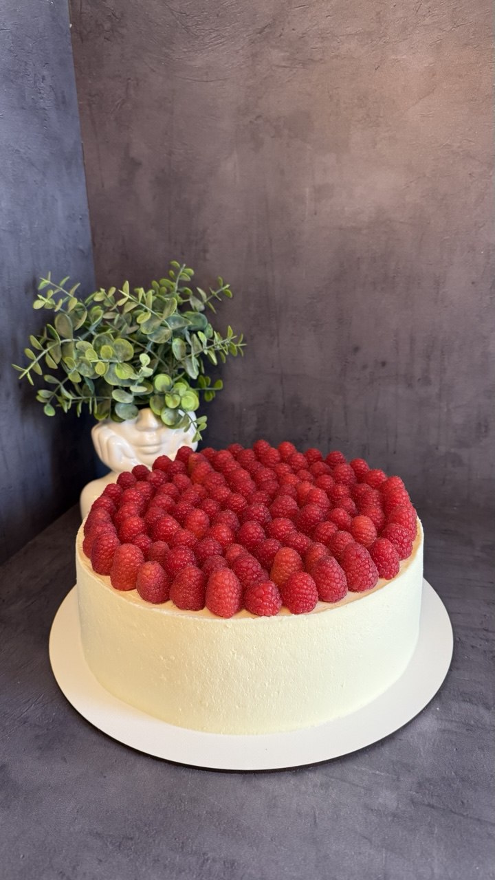 White cake covered with fresh raspberries